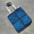 Tote bag fait main en granny square bleu et noir, avec anses crème, crocheté en fil Grundl.