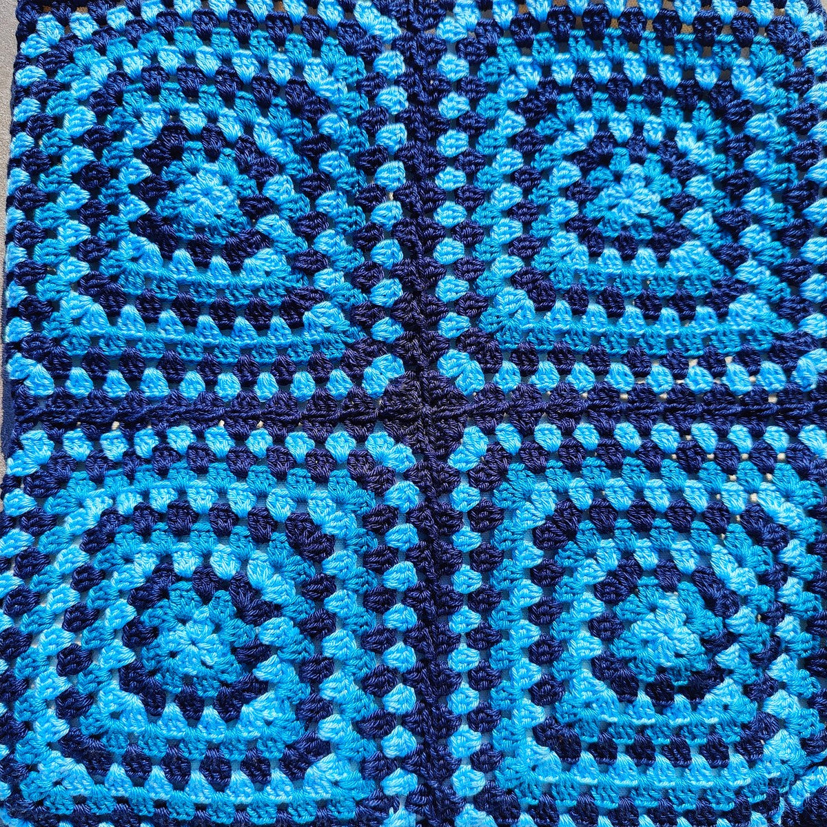 Tote bag fait main en granny square bleu et noir, avec anses crème, crocheté en fil Grundl.