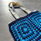 Tote bag fait main en granny square bleu et noir, avec anses crème, crocheté en fil Grundl.