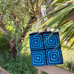 Tote bag fait main en granny square bleu et noir, avec anses crème, crocheté en fil Grundl.