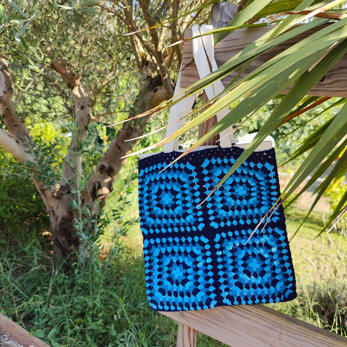 Tote bag fait main en granny square bleu et noir, avec anses crème, crocheté en fil Grundl.