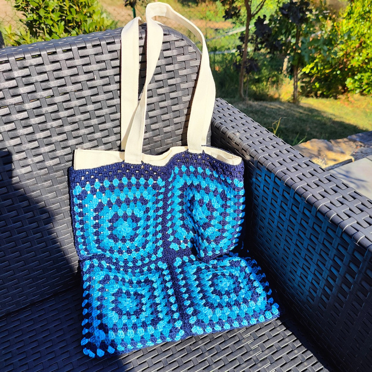 Tote bag fait main en granny square bleu et noir, avec anses crème, crocheté en fil Grundl.
