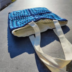 Tote bag fait main en granny square bleu et noir, avec anses crème, crocheté en fil Grundl.