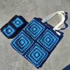 Tote bag fait main en granny square bleu et noir, avec anses crème, crocheté en fil Grundl.
